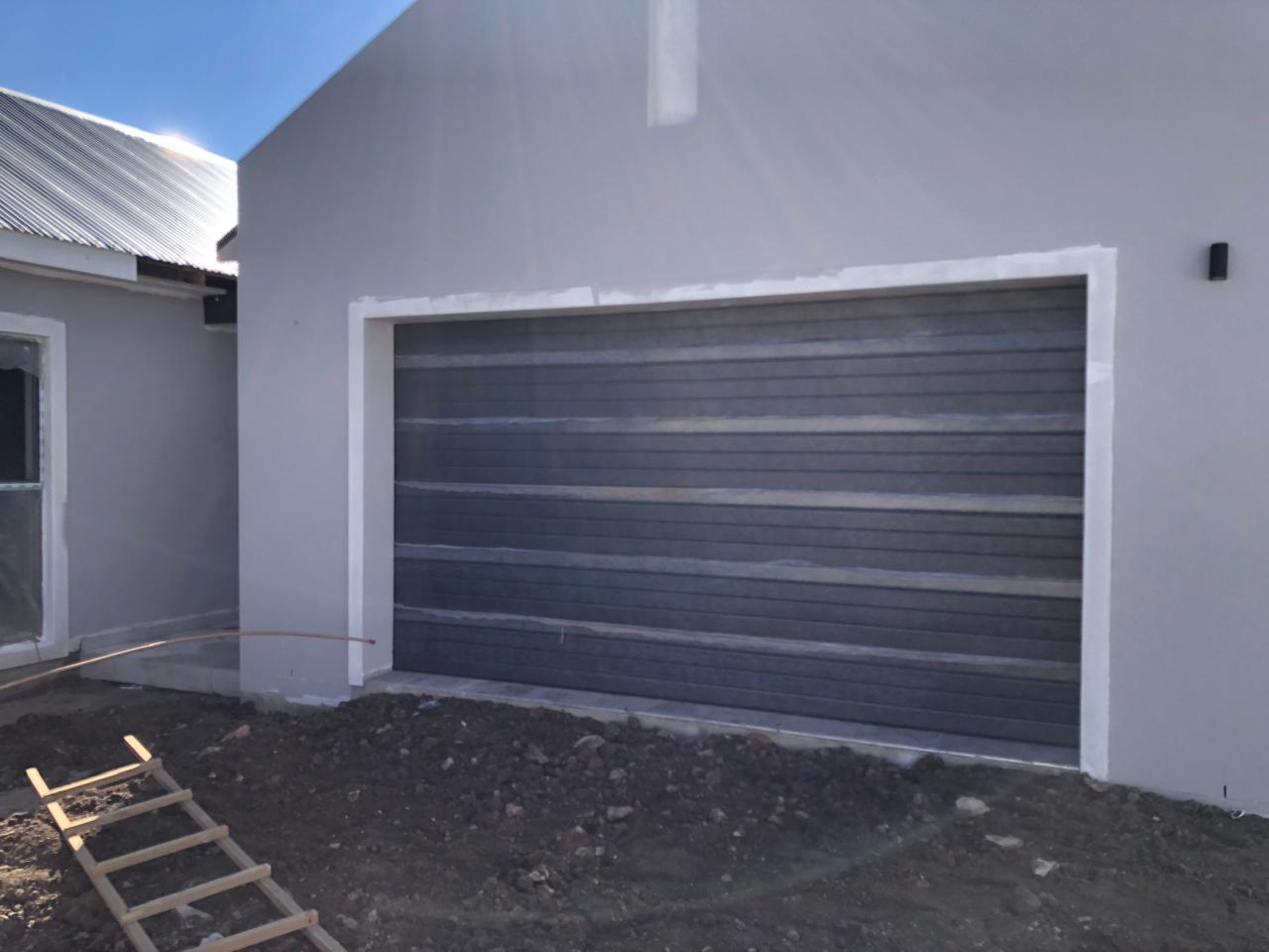 Double sectional garage door spanning one wide opening