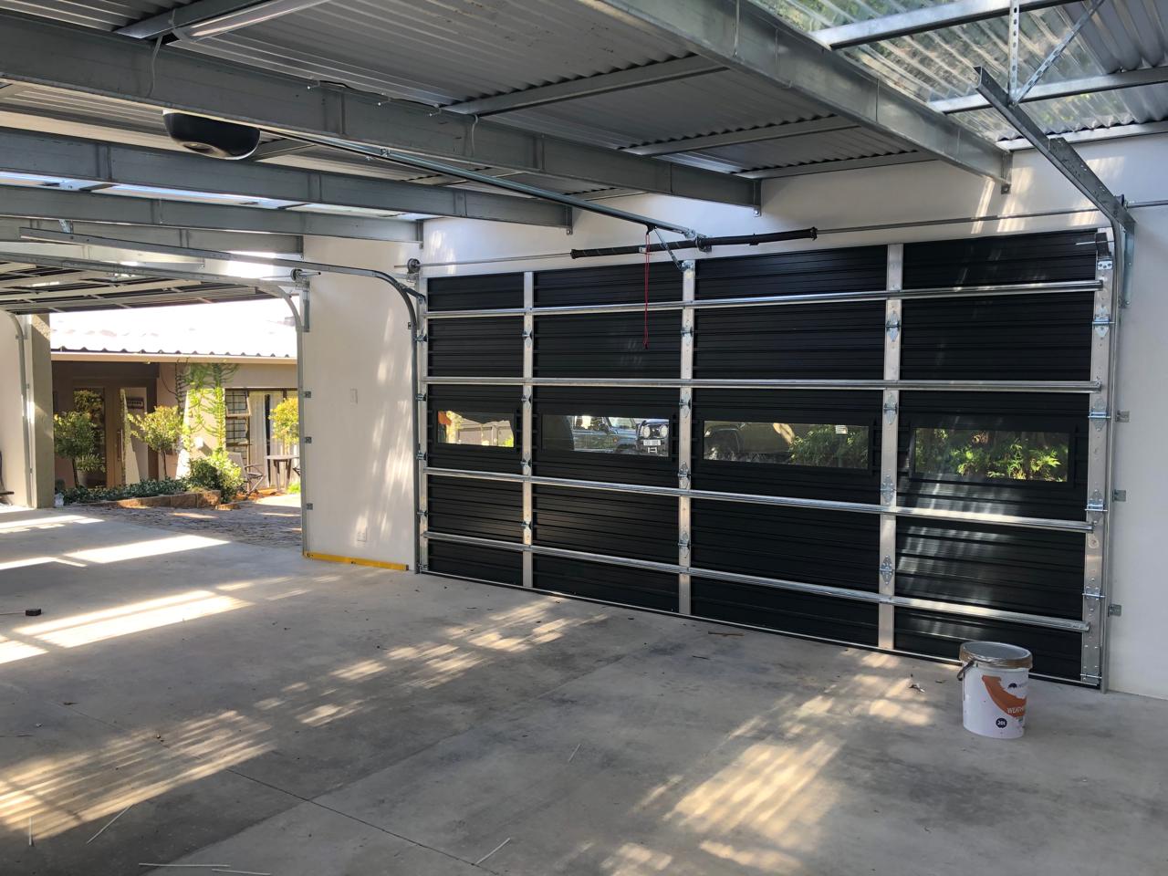 Black framed glazed sectional garage door viewed from inside