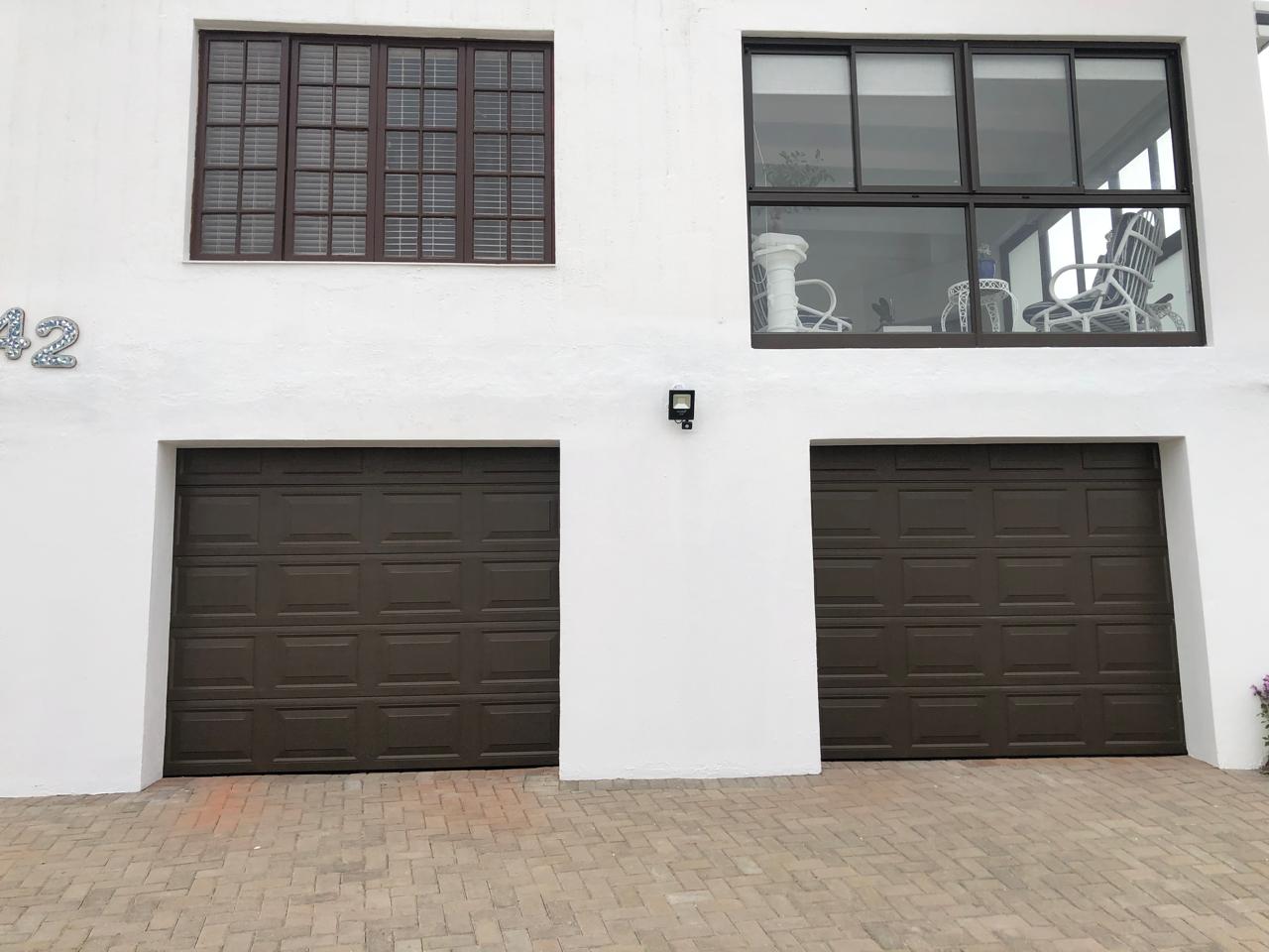 Two single brown panelled sectional garage doors